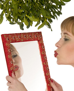 Model kissing herself in a mirror under mistletoe; NOTE: she is a MODEL, not narcissistic!